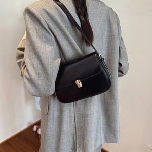 Minimalist black leather crossbody bag with golden clasp and adjustable strap for women