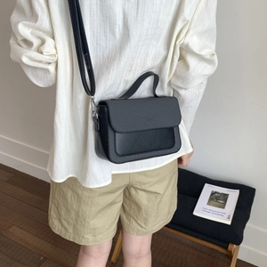 Model view of black woven texture and smooth leather crossbody bag for daily styling