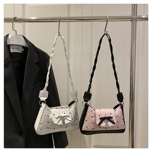 Détail de sacs plissés avec bandoulières tressées et pendentifs en forme de cœur chic