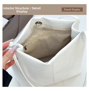 Internal structure of white bucket bag showing zipper pocket and magnetic closure detail