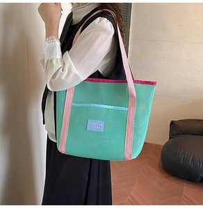 Detail of green mesh tote bag with pink straps and textured contrast fabric design