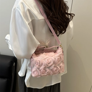 Pink 3D floral shell bag with rose petals and chain strap shown on a model