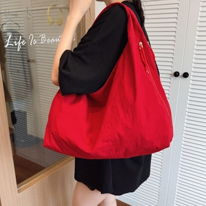 Sac fourre-tout rouge surdimensionné en forme de croissant avec texture polie et zip