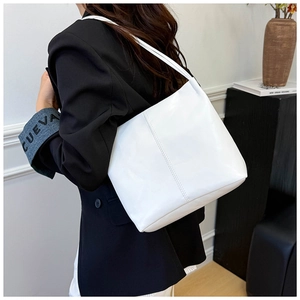 Detail view of a white minimalist PU leather tote bag with vertical stitching and slim strap