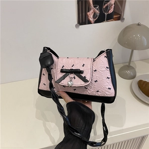 Sac sous le bras croissant rose avec nœuds noirs et pendentif en cœur pour femme chic et moderne