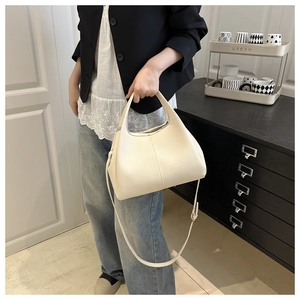 Nahaufnahme der cremefarbenen Handtasche mit Lychee-Muster als Umhängetasche für den Alltag
