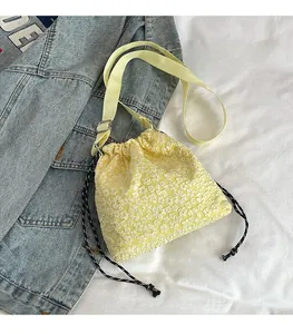 Détail de la texture florale en relief jaune et fermeture par cordon du sac