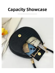 Detail of black faux crocodile leather crescent bag showing storage capacity for essentials