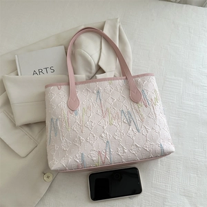 Détail du sac fourre-tout matelassé rose et blanc avec broderie et anses en cuir