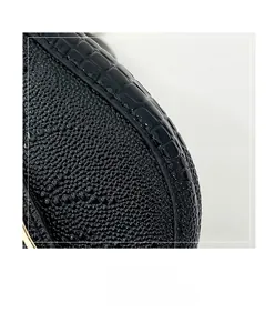 Macro detail of black stone-textured leather underarm bag with sleek metallic frame