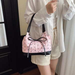 Pink bow jacquard shoulder bag with black faux leather strap and decorative fringe