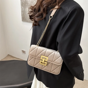 Quilted champagne chain shoulder bag for women styled with an elegant black suit
