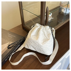 Détail du sac seau jacquard blanc avec cordon de serrage et large bandoulière