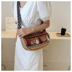 Close-up of ethnic woven bucket bag featuring colorful geometric patterns and tassel details