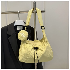 Detail der gelben XL-Segeltuchtasche mit Kordelzug und passendem Mini-Münzbeutel-Anhänger