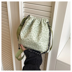 Détail du sac seau vert clair à fleurs avec cordon de serrage et large bandoulière