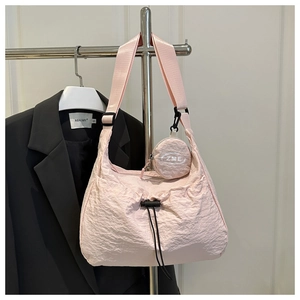 Detail einer rosa plissierten Nylontasche mit Kordelzug und runder kleiner Geldbörse