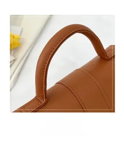 Detail of neat stitching on the comfortable brown leather handle of a chic handbag