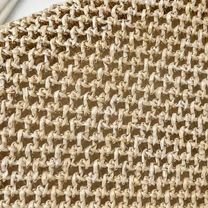 Macro detail van ademende crème stro geweven textuur op een zomerse crossbodytas