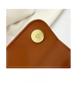 Detail of brown leather handbag with gold magnetic clasp and fine lychee texture