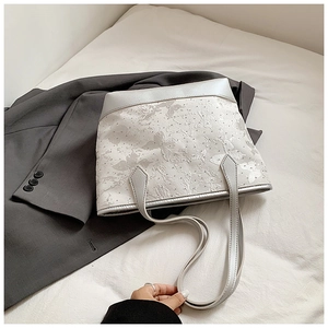 Detail of silver tote bag featuring butterfly jacquard and sparkling rhinestones