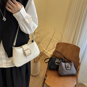 Retro underarm bag with large gold buckle in cream, black, and brown leather options