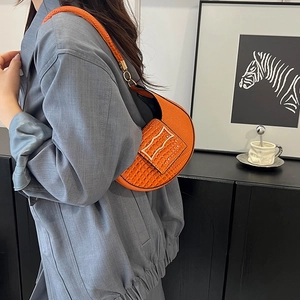 Minimalist orange half-moon shoulder bag with crocodile texture and golden H buckle
