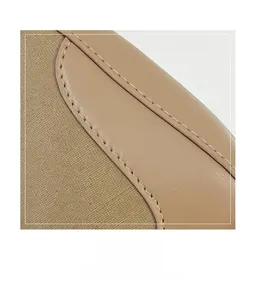 Detailed macro view of beige leather and khaki canvas stitching on a saddle bag