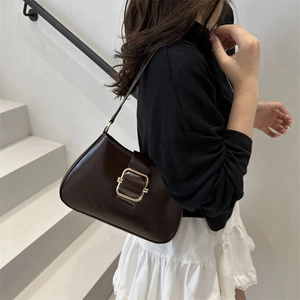 Retro minimalist dark brown leather underarm bag with gold buckle on white stairs