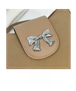 Detail of leather saddle bag with canvas trim and a silver metal bow buckle