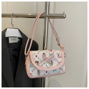 Detail showing the white embossed fabric with cute cartoon prints and pink bow on the bag