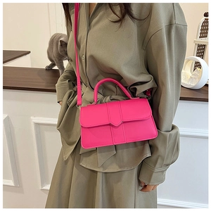 Détail d'un mini sac bandoulière rose fuchsia avec rabat enveloppe et poignée supérieure