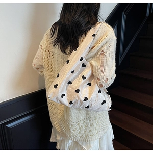 Détail du sac cabas à motif cœur avec texture plissée sur l'épaule du mannequin