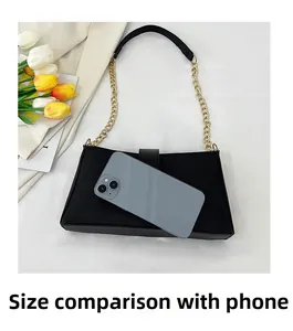 Dettaglio della borsa a spalla nera che mostra il confronto dimensionale con uno smartphone