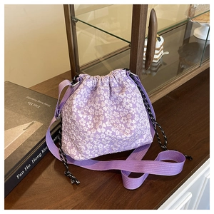 Detail of floral jacquard drawstring bucket bag with purple strap and textured fabric