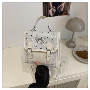 Detailansicht der cremeweißen Tasche mit Herzprint und eleganter Metallschnalle