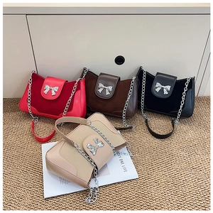 Detail of minimalist saddle bags in four colors with butterfly bow hardware and chain straps