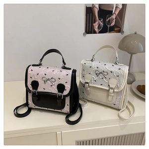 Detail of college style mini backpacks with bow patterns and silver metal bow buckles