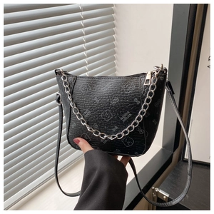 Détail du sac seau en cuir grainé noir avec motif ours et chaîne en métal argenté