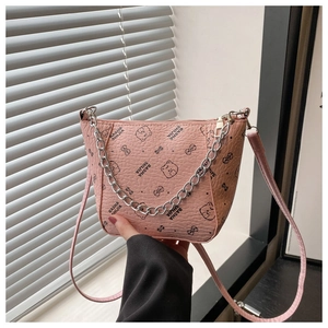 Détail du sac seau rose en cuir avec chaîne argentée et motif d'ours mignon imprimé
