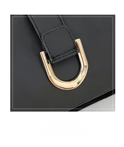 Dettaglio di borsa in pelle nera con un'elegante fibbia metallica a forma di U dorata