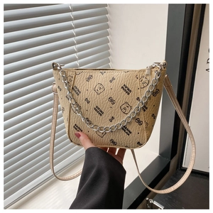 Détail du sac beige avec motifs ours, texture litchi et bandoulière chaîne argentée