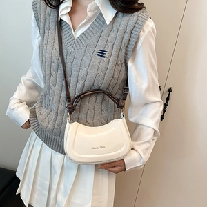 Minimalist white crescent shoulder bag with brown strap shown on model for daily commute