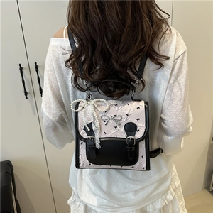 Pink jacquard backpack with black bow patterns and elegant silver metal bow detail