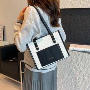 Contrast woven leather tote bag with black front pocket and sleek shoulder straps