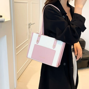 Pink and white contrast leather tote bag with gold studs shown on a model's shoulder