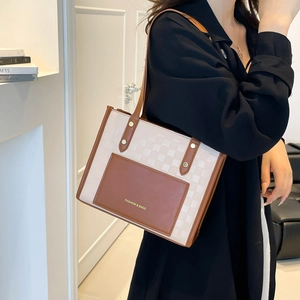 Minimalist tote bag with checkered pattern and brown leather straps worn by model