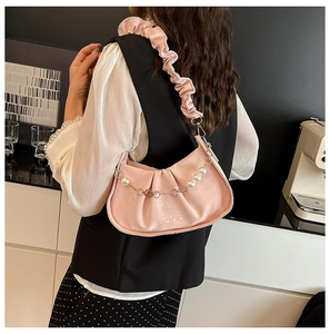 Détail du sac nuage plissé rose doux avec bandoulière à volants et chaîne en perles