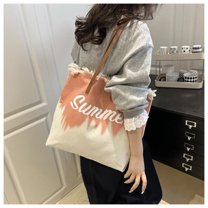 Detail of frayed edge canvas tote bag with Summer print and brown leather handle