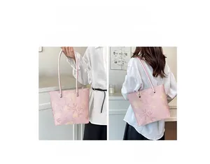 Détail d'un sac cabas à fleurs roses montrant le porté main et le porté épaule